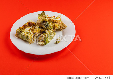 Savory casserole with egg, broccoli, and chicken fillet on a bright plate 124829551