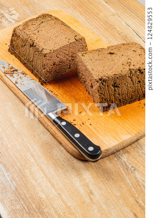 Homemade chicken liver pate served on a wooden cutting board with knife 124829553