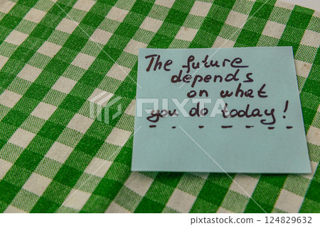 Motivational note placed on checkered tablecloth for daily inspiration 124829632