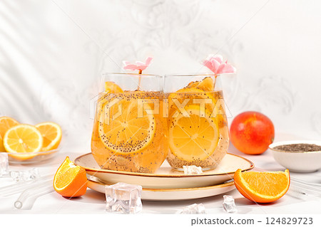 Diet vegan cocktail with chia seeds, orange, lime, violet and ice. Detox diet and weight loss concept. Summer party and healthy lifestyle advertising. Summer banner and screen template. Diet vegan cocktail with chia seeds, orange, lime, violet and ice. Detox diet and weight loss concept. Summer party and healthy lifestyle advertising. Summer banner and screen template. 124829723