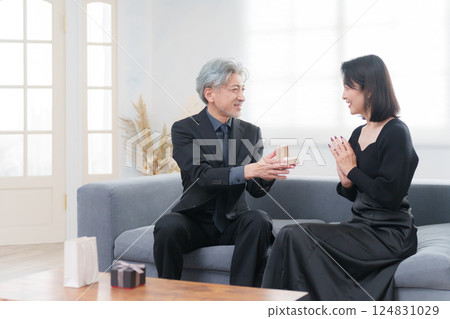 A woman receiving an engagement ring and a proposal from a man (couple) 124831029