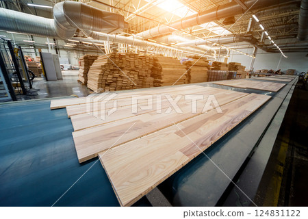 Production line of the wooden floor factory. CNC automatic woodworking machine. Production line of the wooden floor factory. CNC automatic woodworking machine. 124831122