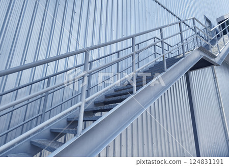 A set of stairs ascending a large blue wall A set of stairs ascending a large blue wall 124831191