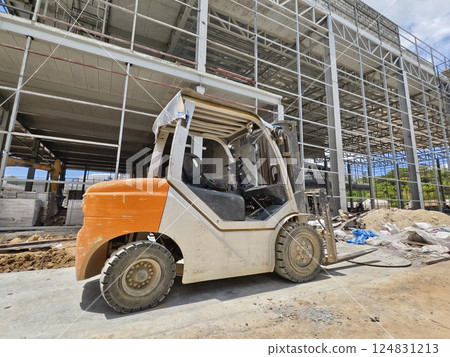 A forklift is parked in front of a building under construction 124831213