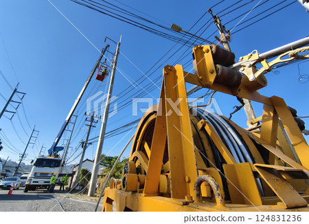 Installation of high-voltage electric wires on new poles along the road Installation of high-voltage electric wires on new poles along the road 124831236