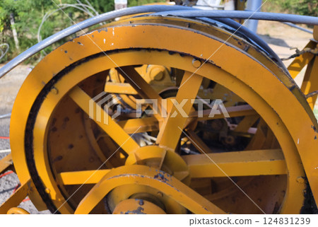 A large wooden spool of high-voltage electric wires is located on the road 124831239