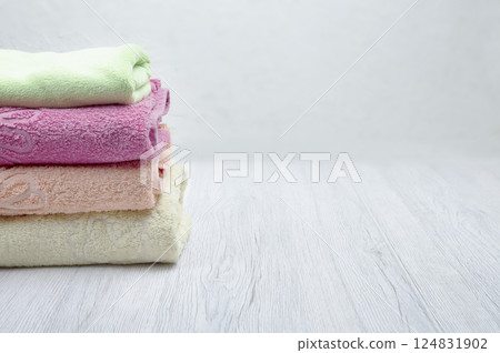 A stack of clean towels placed on a light background, ideal for self-care in hotel or spa settings, with copyspace available. A stack of clean towels placed on a light background, ideal for self-care in hotel or spa settings, with copyspace available. 124831902