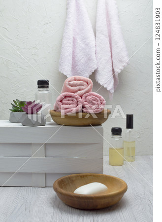 Clean pink towels stacked in a bathroom with shampoo, conditioner, and soap on display, side view and copyspace available. Clean pink towels stacked in a bathroom with shampoo, conditioner, and soap on display, side view and copyspace available. 124831903