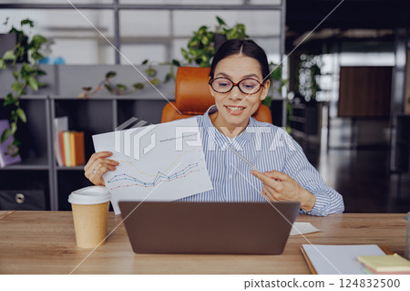 A skilled and professional woman is giving a presentation of data in a modern office environment 124832500