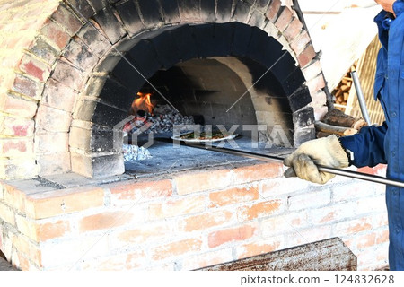 Pizza baking in a wood-fired pizza oven - food background material Pizza baking in a wood-fired pizza oven - food background material 124832628