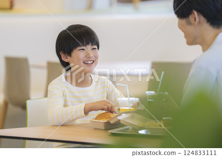 父母和孩子吃漢堡 微笑的 9 歲男孩 124833111