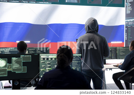 Dishonest person in a Russian cyber security room hacking systems, spreading misinformation and fake news. Russian hackers group on hybrid war tactics and international conflict. Dishonest person in a Russian cyber security room hacking systems, spreading misinformation and fake news. Russian hackers group on hybrid war tactics and international conflict. 124833140