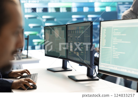 Governmental hacker investigating cyber incidents and monitoring security threats on a big screen. Woman specialist uses phishing techniques to steal important information for cyberwarfare. Governmental hacker investigating cyber incidents and monitoring security threats on a big screen. Woman specialist uses phishing techniques to steal important information for cyberwarfare. 124833257