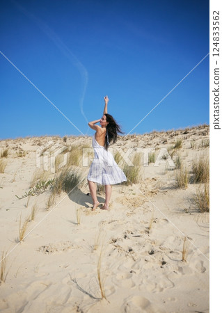 Summer fashion shoot on sand dunes with clear sky and wild beach style 124833562