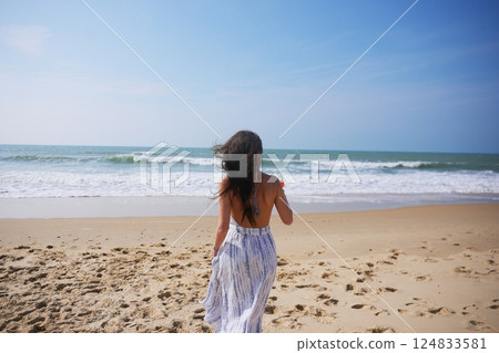 Woman cheers with cocktail on beach during sunny seaside celebration Woman cheers with cocktail on beach during sunny seaside celebration 124833581