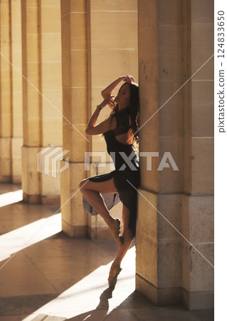 Ballet dancer posing in warm sunlight arcade Ballet dancer posing in warm sunlight arcade 124833650