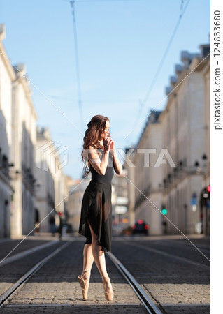 Ballet dancer on pointe in sunlit street 124833680