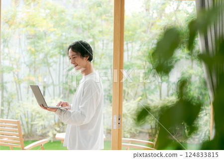 窗邊拿著筆電的男人 窗邊拿著筆電的男人 124833815
