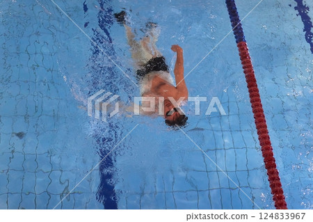 Man swimming in a pool back stroke 124833967