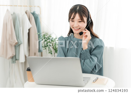 A woman wearing a headset and using a computer 124834193