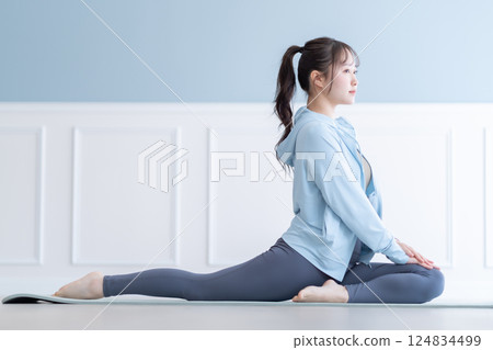 A young woman stretching with a flexible body A young woman stretching with a flexible body 124834499
