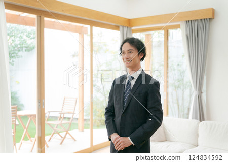 A young man in a suit smiling in a model room A young man in a suit smiling in a model room 124834592