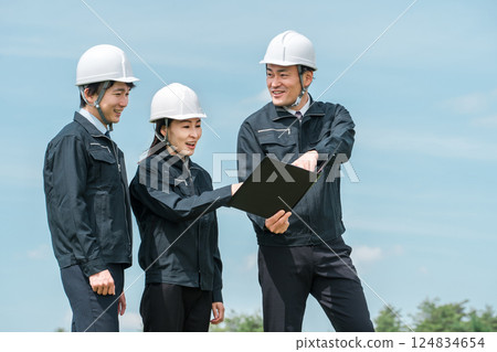Male and female construction workers at a construction site 124834654