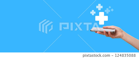 A hand holds a sleek mobile device with health graphics on a blue background A hand holds a sleek mobile device with health graphics on a blue background 124835088