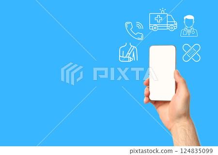 A hand holds a smartphone showing health service icons for emergencies A hand holds a smartphone showing health service icons for emergencies 124835099