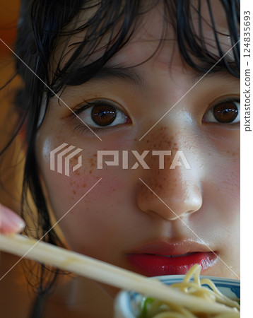 A woman eating fried noodles 124835693