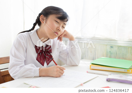 A girl taking a nap during class 124836417