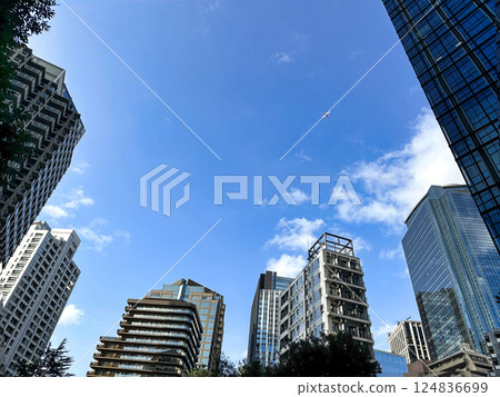 Urban high-rise apartment building with blue sky and white clouds, daytime 124836699