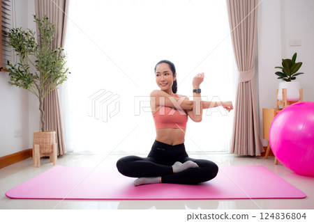 Beautiful young asian woman sitting workout with warmup and stretch muscle arm and hands. 124836804