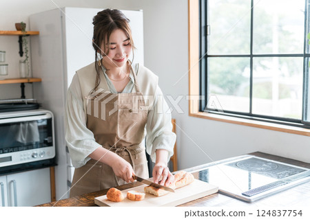 女人在廚房裡切法國麵包 124837754