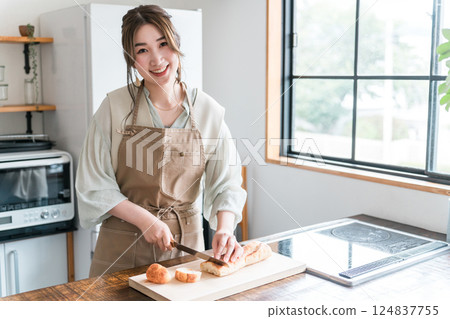 女人在廚房裡切法國麵包 124837755