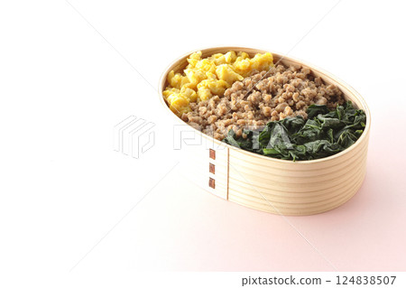 Three-color bento box with egg, meat, and spinach 124838507