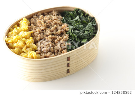 Three-color bento box with egg, meat, and spinach photographed on white background 124838592