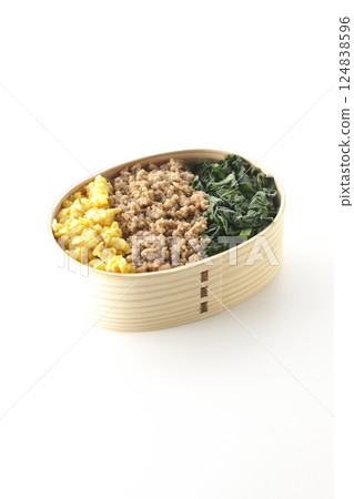 白色背景下拍攝的三色便當盒，內有雞蛋、肉和菠菜 124838596