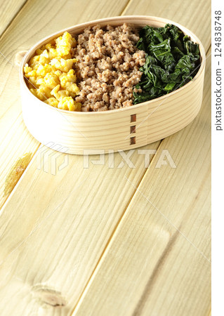 Three-color bento box with egg, meat, and spinach 124838748
