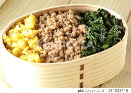 Three-color bento box with egg, meat, and spinach 124838749