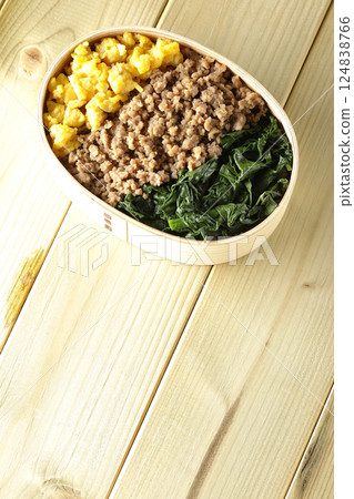 Three-color bento box with egg, meat, and spinach 124838766