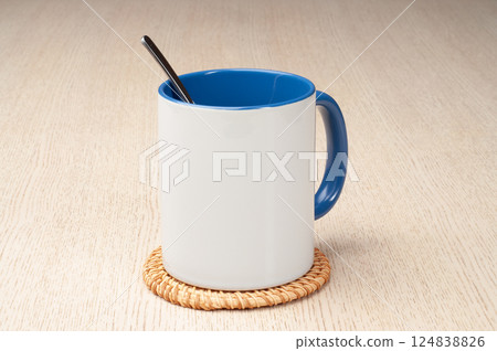 Two-tone 11oz mug on the mug coaster on the table. Mug with spoon, cinnamon, star anise. Mug with green handle and inner part. Two-tone 11oz mug on the mug coaster on the table. Mug with spoon, cinnamon, star anise. Mug with green handle and inner part. 124838826