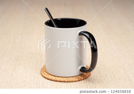 Two-tone 11oz mug on the mug coaster on the table. Mug with spoon, cinnamon, star anise. Mug with green handle and inner part. Two-tone 11oz mug on the mug coaster on the table. Mug with spoon, cinnamon, star anise. Mug with green handle and inner part. 124838838