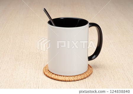 Two-tone 11oz mug on the mug coaster on the table. Mug with spoon, cinnamon, star anise. Mug with green handle and inner part. Two-tone 11oz mug on the mug coaster on the table. Mug with spoon, cinnamon, star anise. Mug with green handle and inner part. 124838840