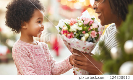 Mothers Day celebration with child giving flowers to smiling mother Mothers Day celebration with child giving flowers to smiling mother 124838913