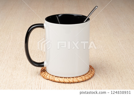 Two-tone 11oz mug on the mug coaster on the table. Mug with spoon, cinnamon, star anise. Mug with green handle and inner part. Two-tone 11oz mug on the mug coaster on the table. Mug with spoon, cinnamon, star anise. Mug with green handle and inner part. 124838931