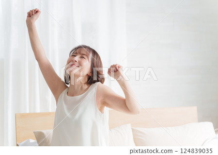 中年婦女早上在床上伸展身體 124839035