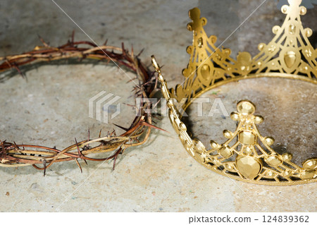 Juxtaposition of a crown of thorns with a golden crown 124839362