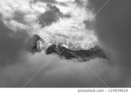 Majestic peaks of the Otztal Alps emerge through swirling clouds, creating a breathtaking view from Wildspitze. A striking combination of nature's beauty and mystery unfolds in this landscape. Majestic peaks of the Otztal Alps emerge through swirling clouds, creating a breathtaking view from Wildspitze. A striking combination of nature's beauty and mystery unfolds in this landscape. 124839628