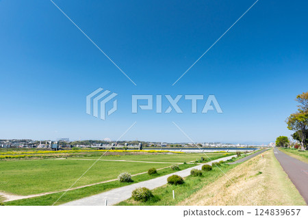 Walking along the cycling road on the Tama River riverbed under the blue spring sky in Chofu, Tokyo Walking along the cycling road on the Tama River riverbed under the blue spring sky in Chofu, Tokyo 124839657
